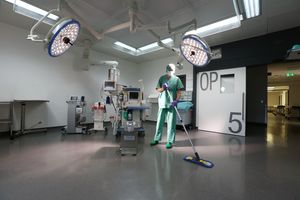 A man is cleaning the floor of an operating theatre.