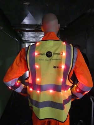 Man in the dark wearing a high-visibility vest equipped with LEDs