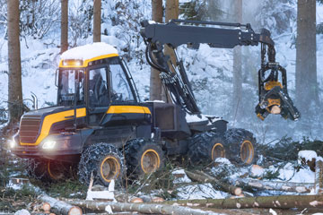 Harvester in action in a snow-covered forest