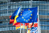 EU flag and flags of several European countries in front of a large building