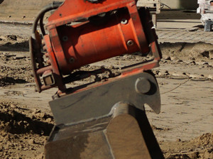 Bilderserie Wechselvorgang einer Schnellwechseleinrichtung an einer Baumaschine: der Bolzen geift in das Werkzeug