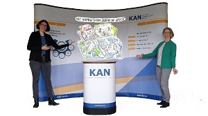 der KANMessestand mit Rückwand und Stehpult mit 2 Mitarbeiterinnen der KAN-Geschäftssltelle