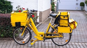 Pedelec von Briefzustellern mit Packtaschen auf Lenker und Gepäcktrager