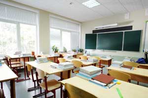 Klassenzimmer mit Stühlen, Tischen, Lehrerpult und Tafel