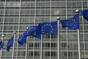 Several EU flags in front of a large building