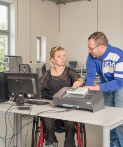 Femme dans un fauteuil roulant travaille à son bureau