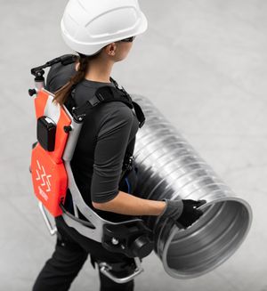 Mensch mit Exoskelett zur Unterstützung bei Hebetätigkeit