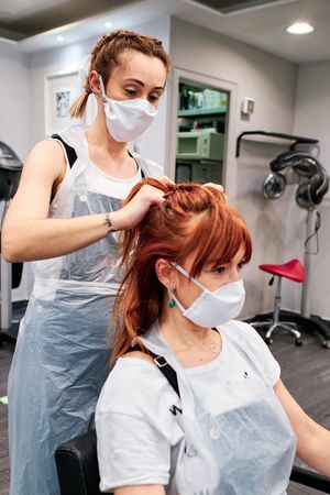 Une coiffeuse travaille sur les cheveux d'une cliente