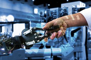 Une main humaine serre la main d’un robot