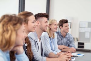 Junge Erwachsene sitzen an einem Konferenztisch