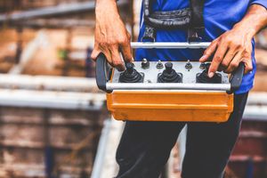 Un ouvrier commande une grue par radiocommande.