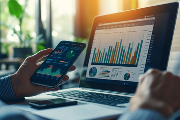 Arbeit am Smartphone und Laptop, Synchronisation von Daten zwischen Laptop und Smartphone.. Klick öffnet die Seite Eurostat: Arbeitsunfälle 2023 in der EU