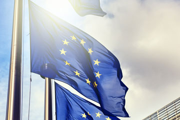 Mehrere Fahnenmasten mit EU-Flaggen. Klick öffnet die Seite KAN veröffentlicht Position zu beschleunigten Normungsprozessen bei CEN/CENELEC und den European Agile Specifications (EAS)