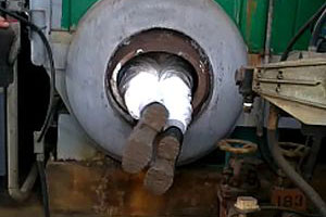 A person is working inside a pressure vessel, with only the feet sticking out of the very small opening.