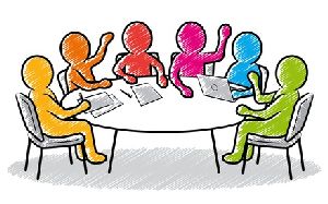 Sechs Beschäftigte sitzen um einen runden Tisch herum und diskutieren.