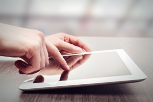 Hands typing on a tablet computer