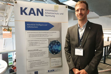 Freeric Meier, Leiter des Sozialpartnerbüros der Arbeitgeber, am Ausstellungsstand der KAN. Klick öffnet die Seite #KANunterwegs auf dem ifaa-Kolloquium in Hürth