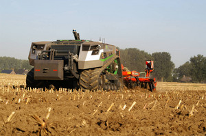 Autonomer Traktor mit angehängtem Pflug fährt auf einem Feld