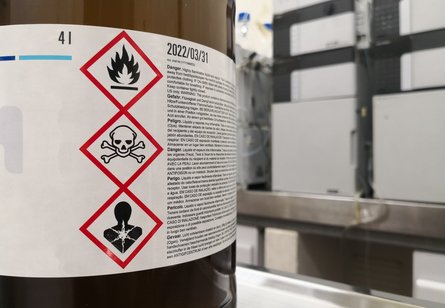 Braune Chemikalienflasche  mit Gefahrenpiktogrammen für entzündbare Flüssigkeit, Toxizität und Gesundheitsgefahr