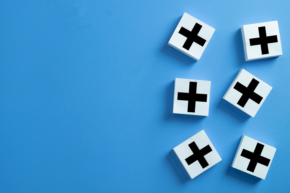 Sechs Würfel mit Plus-Zeichen auf einem blauen Hintergrund