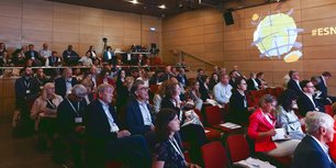 Einige Menschen sitzen in einem Hörsaal und hören zu