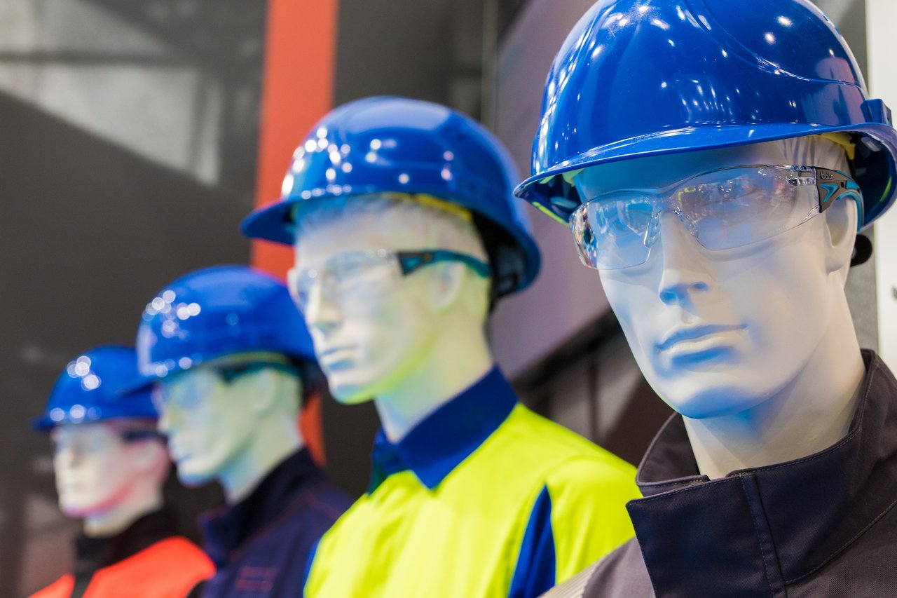 Vier Schaufensterpuppen, die blaue Schutzhelme und Schutzbrillen tragen
