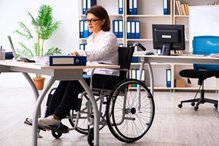 Office workstation: woman in wheelchair sitting at a desk