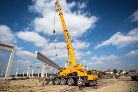 Mobile crane lifting a steel beam