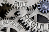 Cogwheels with the words "rule", "guideline", "regulation" on them