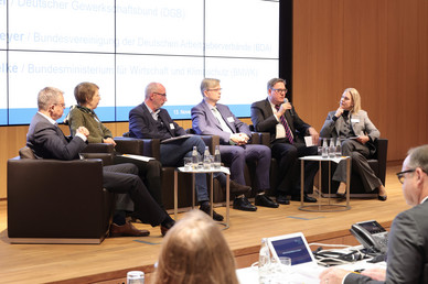 Podiumsdiskussion mit Christoph Winterhalter (DIN), Gisela Eickhoff (Harting Stiftung & Co. KG), Thomas Fischer (Deutscher Gewerkschaftsbund – DGB), Oliver Schollmeyer (Bundesvereinigung der Deutschen Arbeitgeberverbände BDA), Dr. Thomas Zielke (Bundesministerium für Wirtschaft und Klimaschutz – BMWK) und Britta Ibald (DGUV)