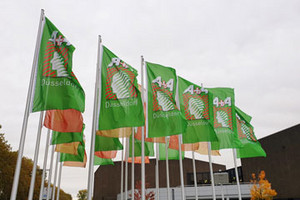 Grüne Flaggen mit dem Logo der A+A Messe Düsseldorf vor dem Messeeingang