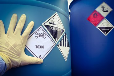 Gefahrensymbole für chemische Gefährdungen auf einem Container für Chemikalien. Klick öffnet die Seite Sicherheit und Gesundheit am Arbeitsplatz 
