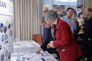 Brigitta Hempel am KAN Messestand im Austausch mit einem Interessierten