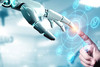 Eine menschliche Hand berührt durch einen transparenten Bildschirm, auf dem verschiedene Symbole abgebildet sind, die Hand eines Roboters.