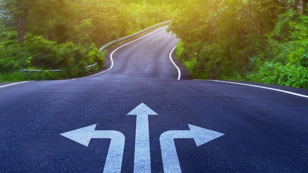 Drei Pfeile auf einer asphaltierten Straße, die in unterschiedliche Richtungen weisen