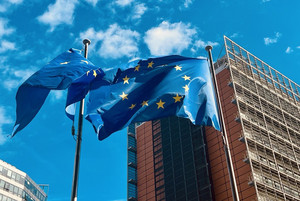 Zwei Fahnenmasten mit wehenden EU-Flaggen vor dem Gebäude der Europäischen Kommission in Brüssel