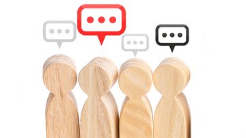 Vier Holzfiguren mit Sprechblasen