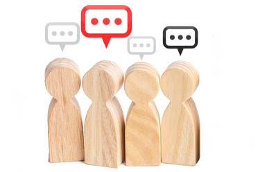 Vier Holzfiguren mit Sprechblasen