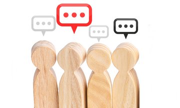 Vier Holzfiguren mit Sprechblasen