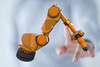 Ein Finger berührt einen kollaborierenden Roboter.