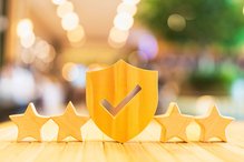Holzschild mit Häkchen und vier Sternen, die für hohe Qualität und Sicherheitstehen