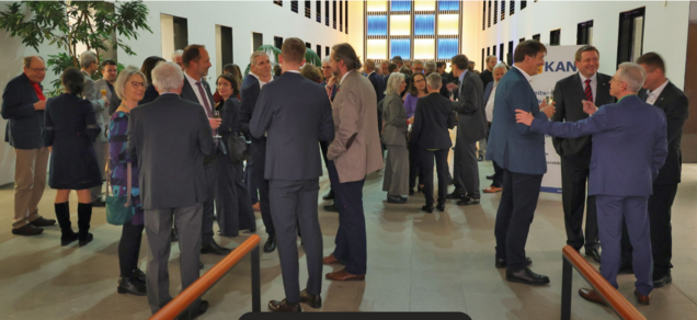 Empfangshalle, mehrere Leute stehen zusammen und unterhalten sich