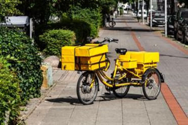Fahrradkurier auf einem gelben Lastenfahrrad 