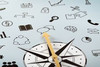 A compass on a background with scribbled icons