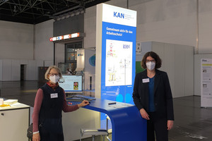 Zwei Personen stehen am Messestand der KAN auf der A+A 2021