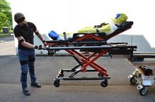 Das Fahrgestell einer elektrohydraulischen Fahrtrage wird vor dem Einladen eingefahren.