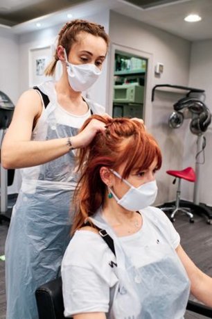 Une coiffeuse travaille sur les cheveux d'une cliente